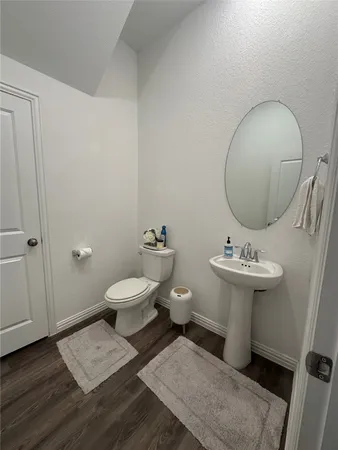 a bathroom with a toilet a sink and mirror