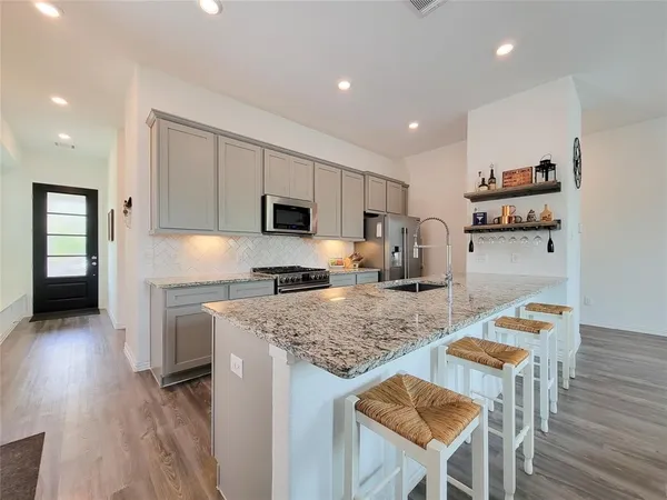 a kitchen with refrigerator and chairs
