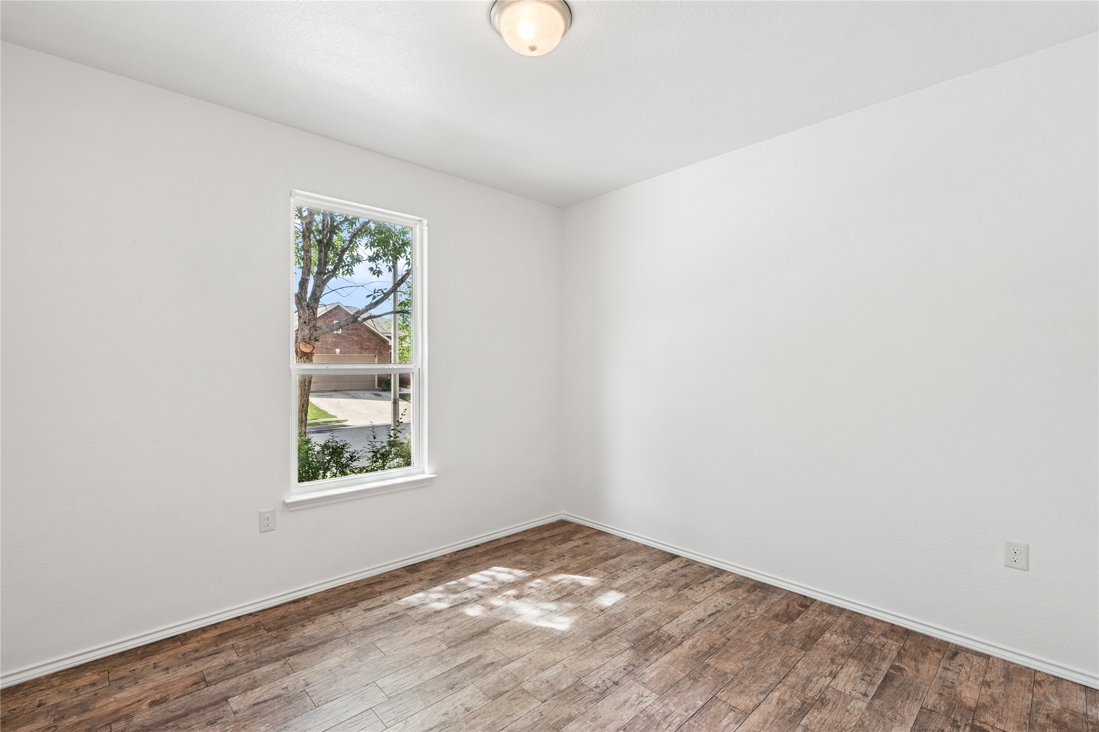 8613 Capitol View Drive Austin, TX 78747 - Photo 4 of 33 Warm wood-look flooring and an elevated window frame treetop views in this inviting space.