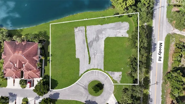 an aerial view of a residential houses with yard and lake view