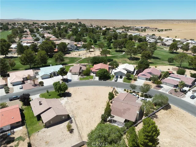 an aerial view of a city with lots of residential buildings ocean and mountain view in back