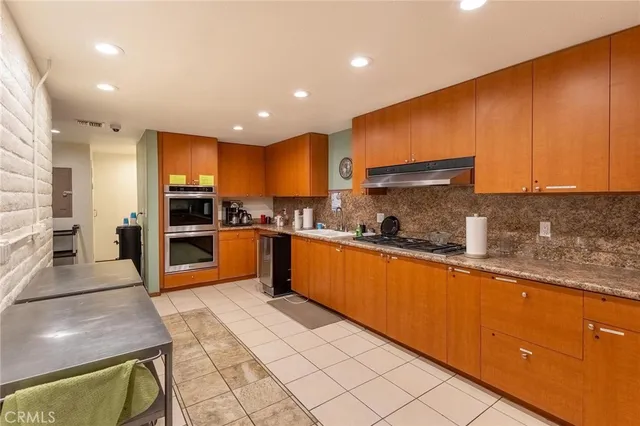 a kitchen with stainless steel appliances granite countertop a stove a sink and a refrigerator