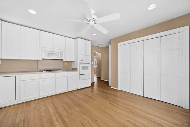 a kitchen with granite countertop white cabinets and white appliances