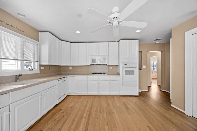 a view of a dining room with furniture a chandelier and wooden floor