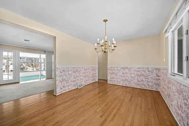 an empty room with wooden floor and window