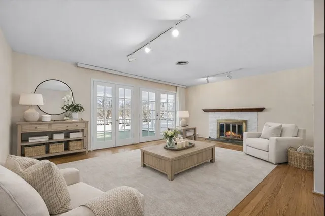 a view of an empty room with a fireplace and wooden floor