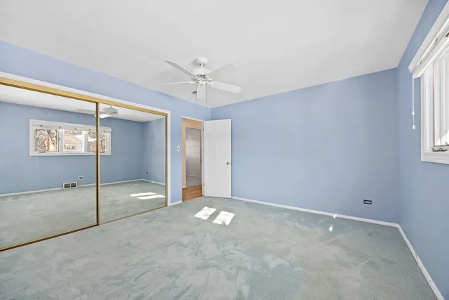 a view of a hallway with a ceiling fan