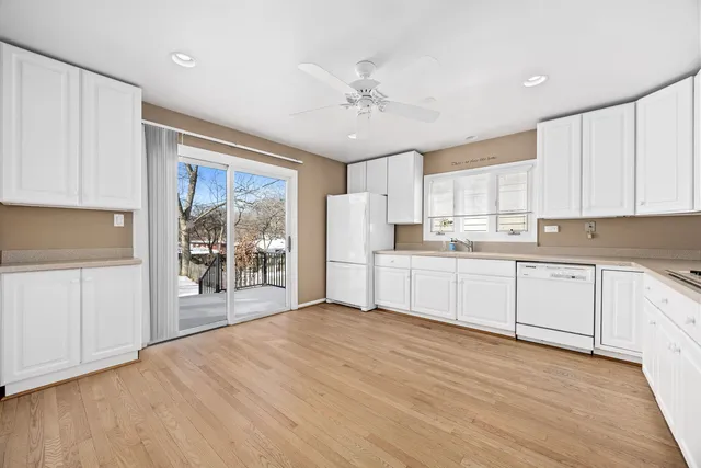 a kitchen with granite countertop white cabinets and white appliances