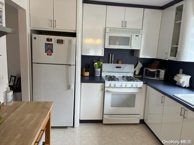159-15 80th Street Queens, NY 11414 - Photo 2 of 13 a kitchen with stainless steel appliances white cabinets and a refrigerator
