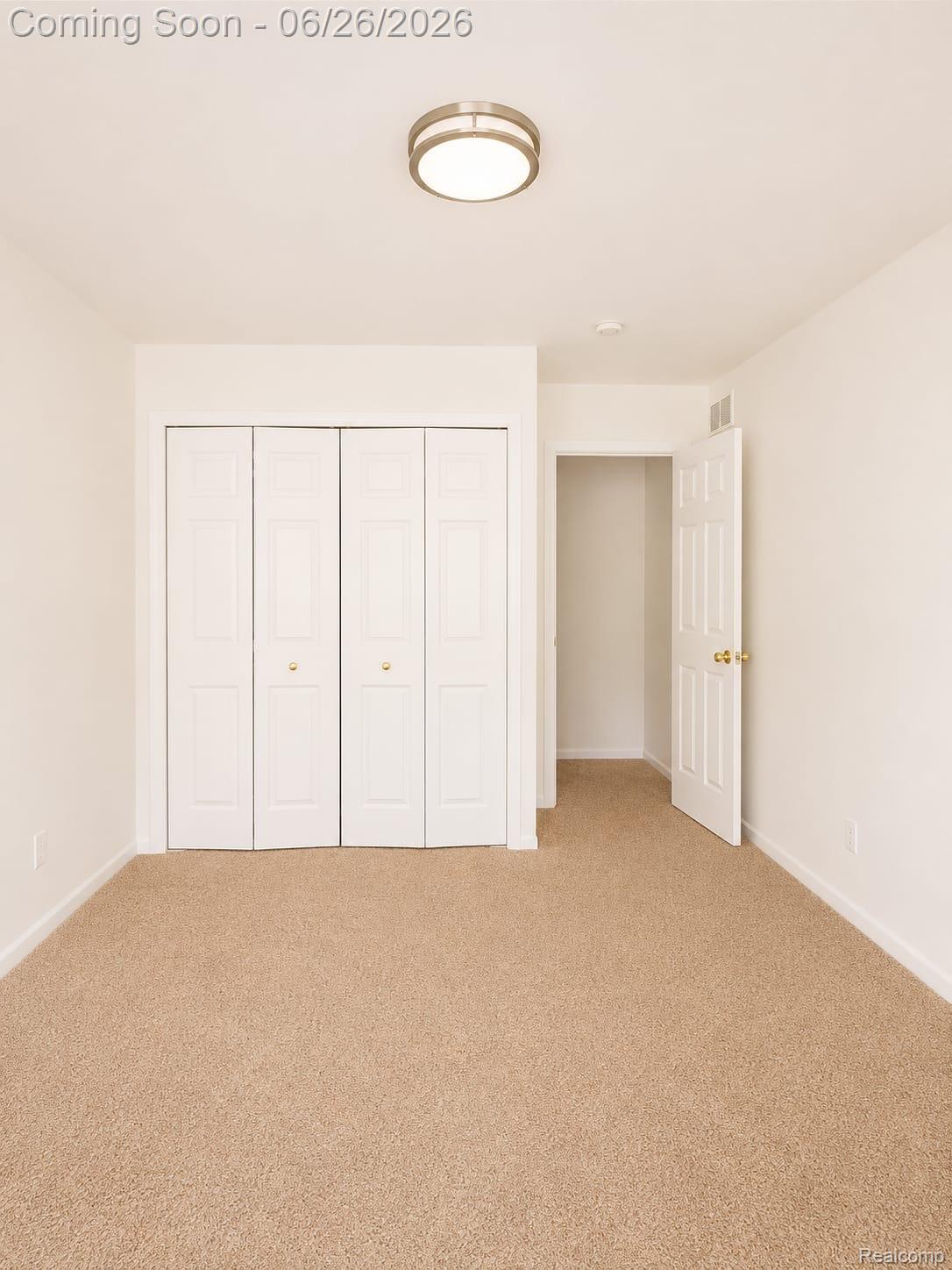 17014 Country Ridge Lane Macomb, MI 48044 - Photo 7 of 25 Neutral-toned carpeting extends throughout this interior space, featuring white bi-fold closet doors and a flush-mount ceiling light fixture