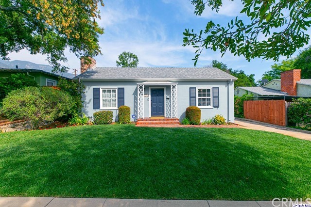 a view of a house with a backyard and a tree