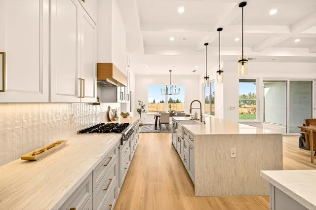a living room with furniture kitchen view and large windows