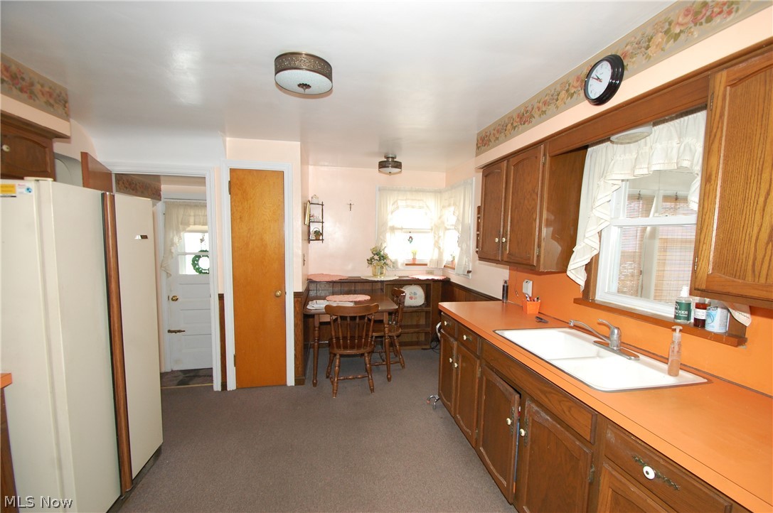 189 Creed Street Struthers, OH 44471 - Photo 8 of 14 Kitchen featuring white fridge, light carpet, and sink