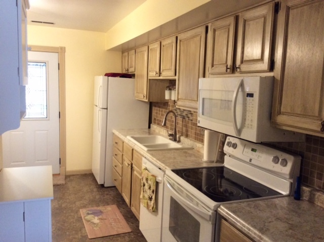 23 Cherry Hill, Unit 124 Hampton, IL 61256 - Photo 21 of 25 a kitchen with granite countertop a sink a stove and refrigerator