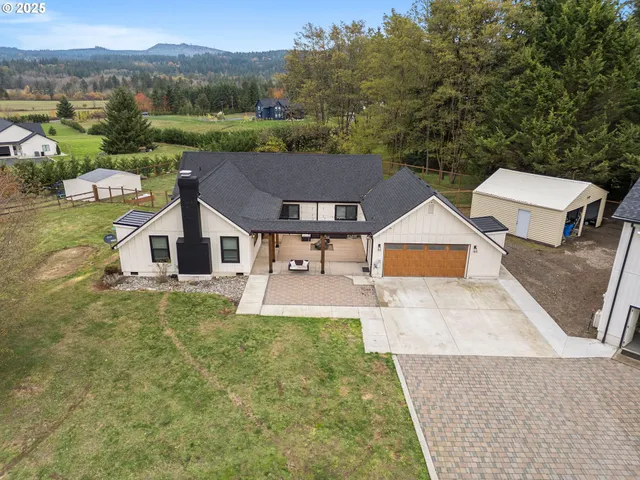 a view of a house with a yard and large tree