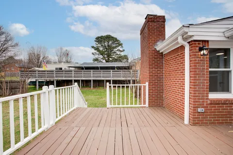 a view of a balcony with wooden floor and fence