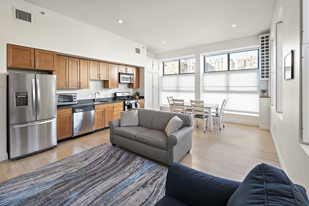 1 Garden Street, Unit FOUR Boston, MA 02114 - Photo 1 of 14 a living room with furniture and a large window