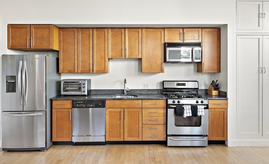 1 Garden Street, Unit FOUR Boston, MA 02114 - Photo 2 of 14 a kitchen with stainless steel appliances granite countertop a stove a sink and a refrigerator