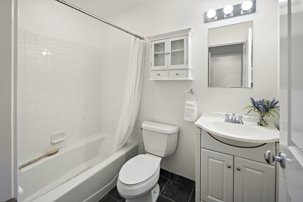 1 Garden Street, Unit FOUR Boston, MA 02114 - Photo 8 of 14 a white toilet sitting next to a bathroom sink