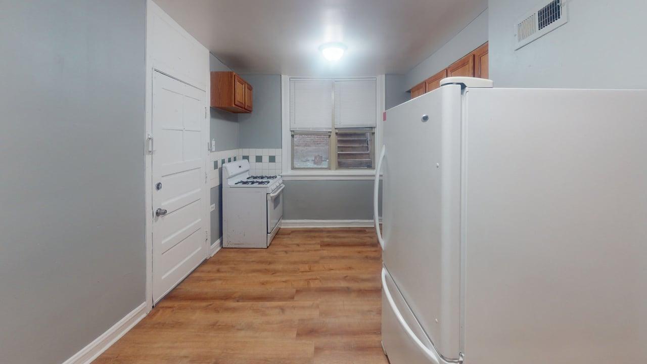 823 West 83rd Street, Unit GARDEN Chicago, IL 60620 - Photo 6 of 6 a kitchen with cabinets and wooden floor