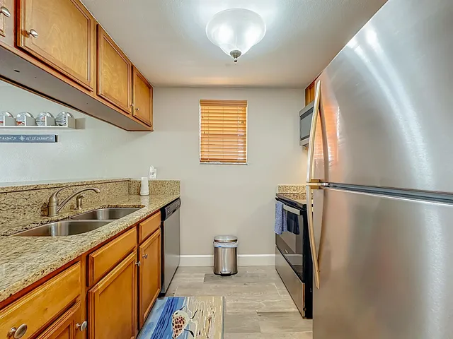 a kitchen with stainless steel appliances granite countertop a sink and refrigerator