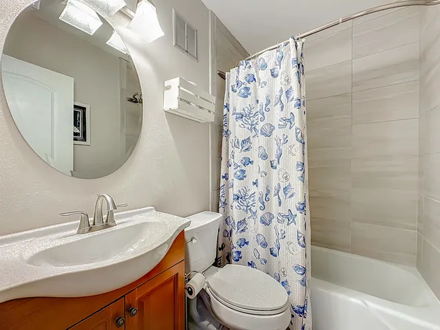 a bathroom with a sink a toilet and shower curtain