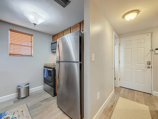 a view of a refrigerator in kitchen and wooden floor