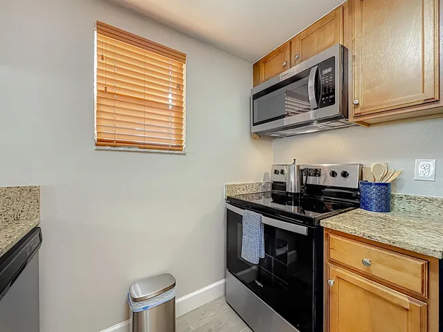 a kitchen with stainless steel appliances wooden cabinets and a stove top oven