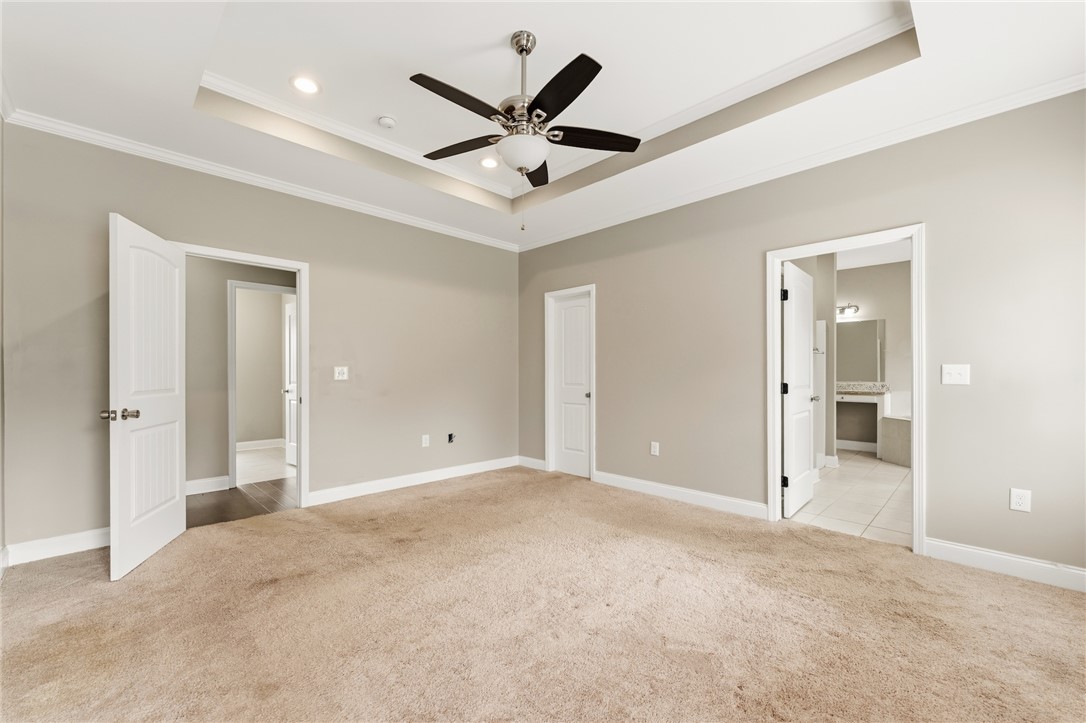 1411 Dunn Road Anderson, SC 29625 - Photo 17 of 30 This spacious bedroom offers comfortable carpeting and a luxurious tray ceiling, perfect for unwinding.