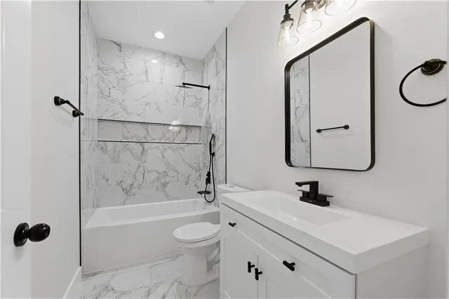 a bathroom with a sink a toilet and shower