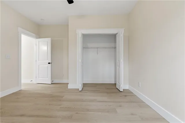 a view of an empty room with a window and a chandelier fan