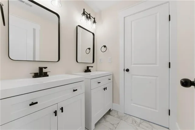 a bathroom with double vanity sinks and a mirror