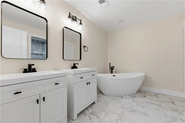 a spacious bathroom with a double vanity sink mirror and toilet