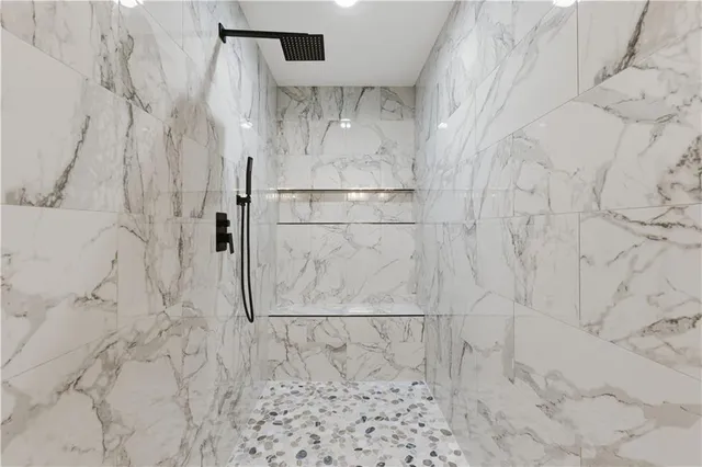 a bathroom with a white tub a sink and mirror