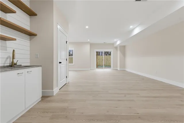 an empty room with wooden floor and bathroom
