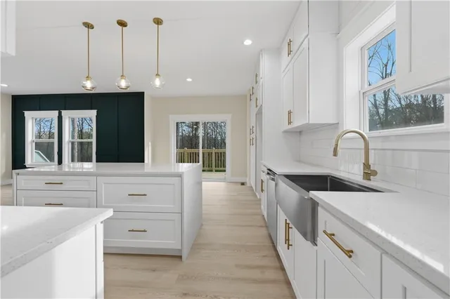 a kitchen with granite countertop a sink and white cabinets