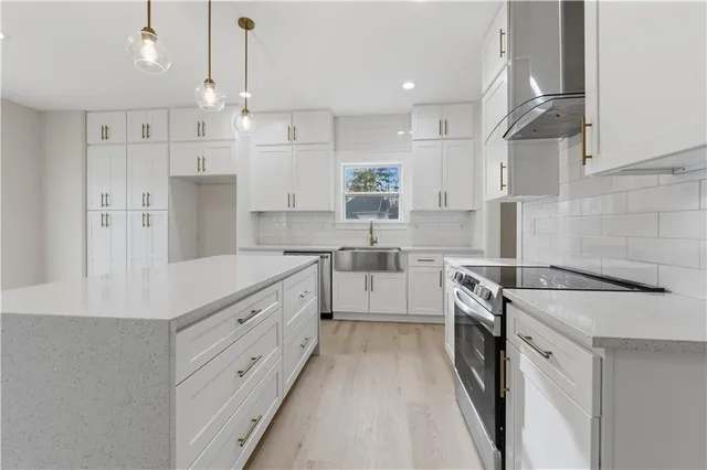 a kitchen with stainless steel appliances sink stove top oven and cabinets