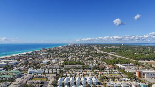 a view of a patio with table and chairs under an umbrella with palm trees