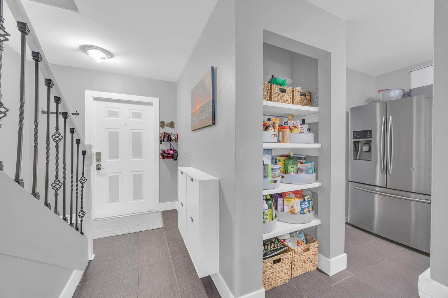 170 Timberwalk Trail Jupiter, FL 33458 - Photo 4 of 28 a room with a refrigerator and a wooden floor