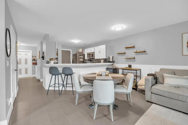a dining room with furniture and a kitchen view