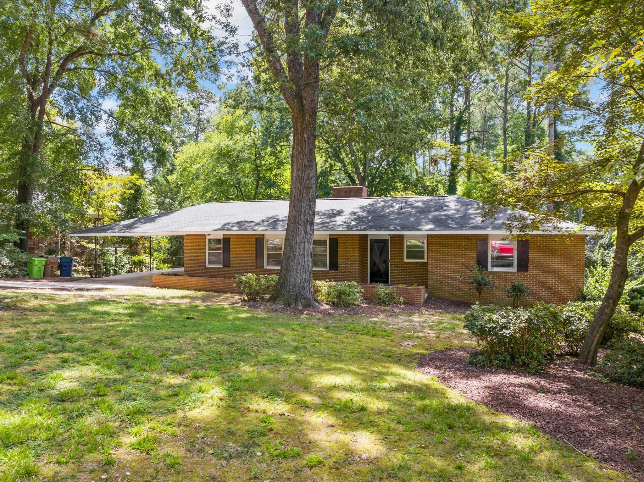 3605 Octavia Street Raleigh, NC 27606 - Photo 19 of 50 a front view of house with yard and trees in the background