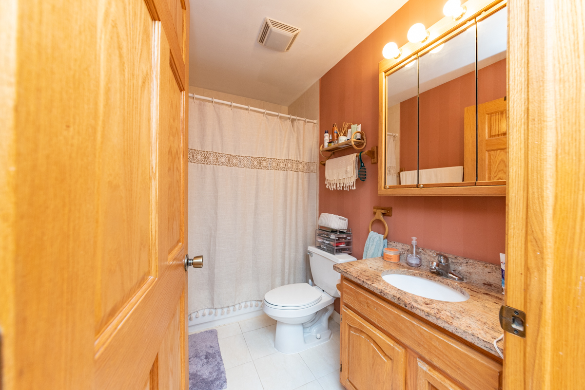 2932 North Ridgeway Avenue, Unit 1 Chicago, IL 60618 - Photo 12 of 25 a bathroom with a granite countertop sink toilet and shower