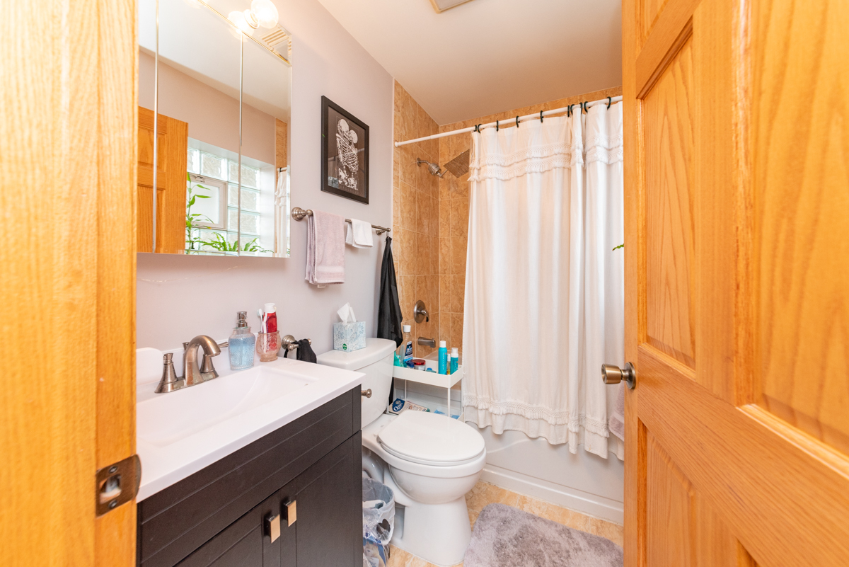 2932 North Ridgeway Avenue, Unit 1 Chicago, IL 60618 - Photo 16 of 25 a bathroom with a sink a toilet and shower curtain