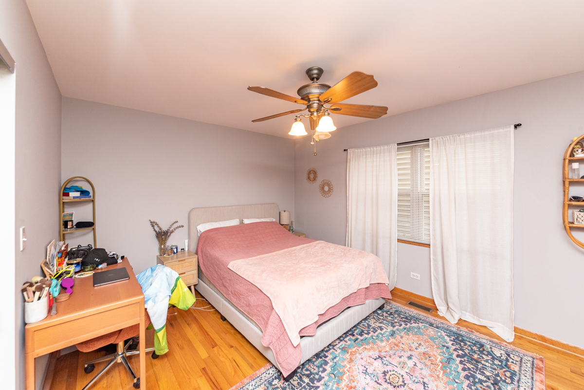 2932 North Ridgeway Avenue, Unit 1 Chicago, IL 60618 - Photo 10 of 25 a bedroom with a bed and a chandelier