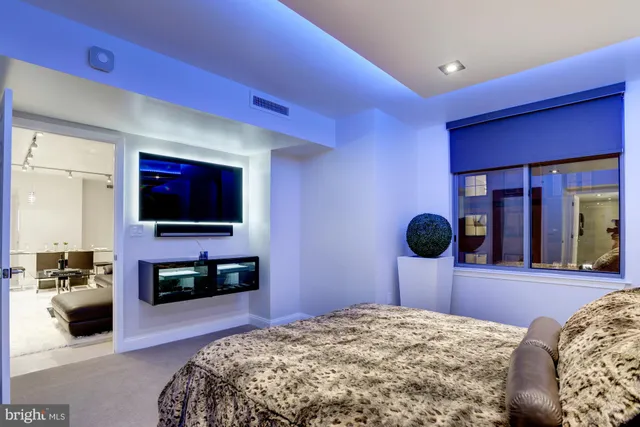 a living room with stainless steel appliances kitchen island granite countertop furniture and a flat screen tv