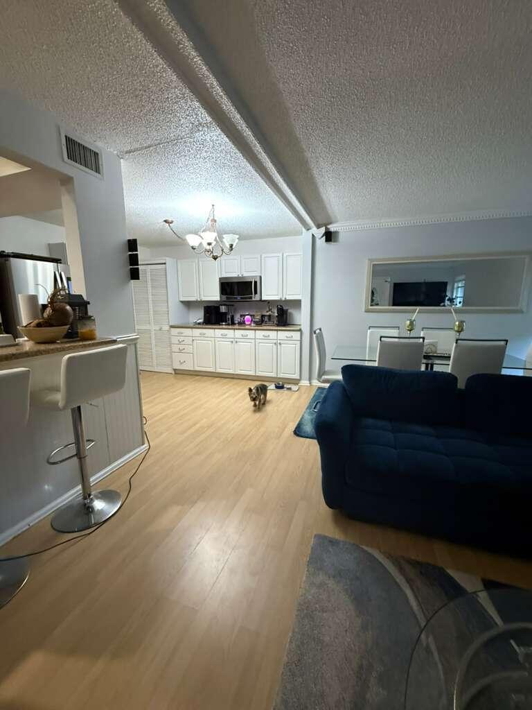 7024 Northwest 63rd Street Tamarac, FL 33321 - Photo 15 of 50 a living room with kitchen furniture and a flat screen tv