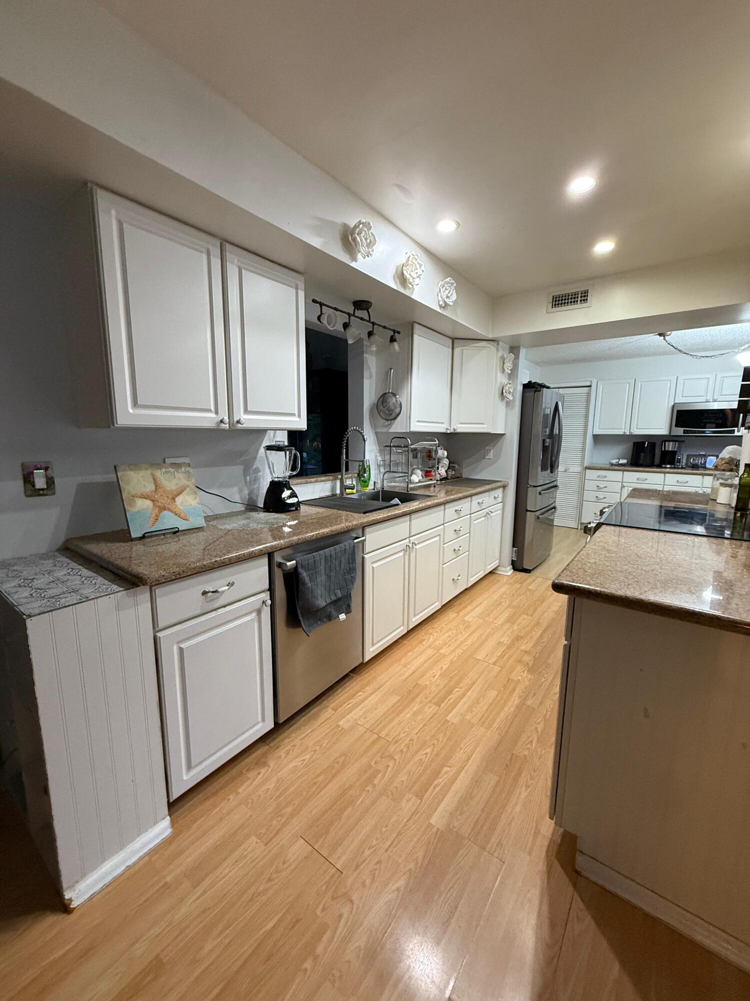 7024 Northwest 63rd Street Tamarac, FL 33321 - Photo 17 of 50 a kitchen with stainless steel appliances granite countertop a stove sink and cabinets