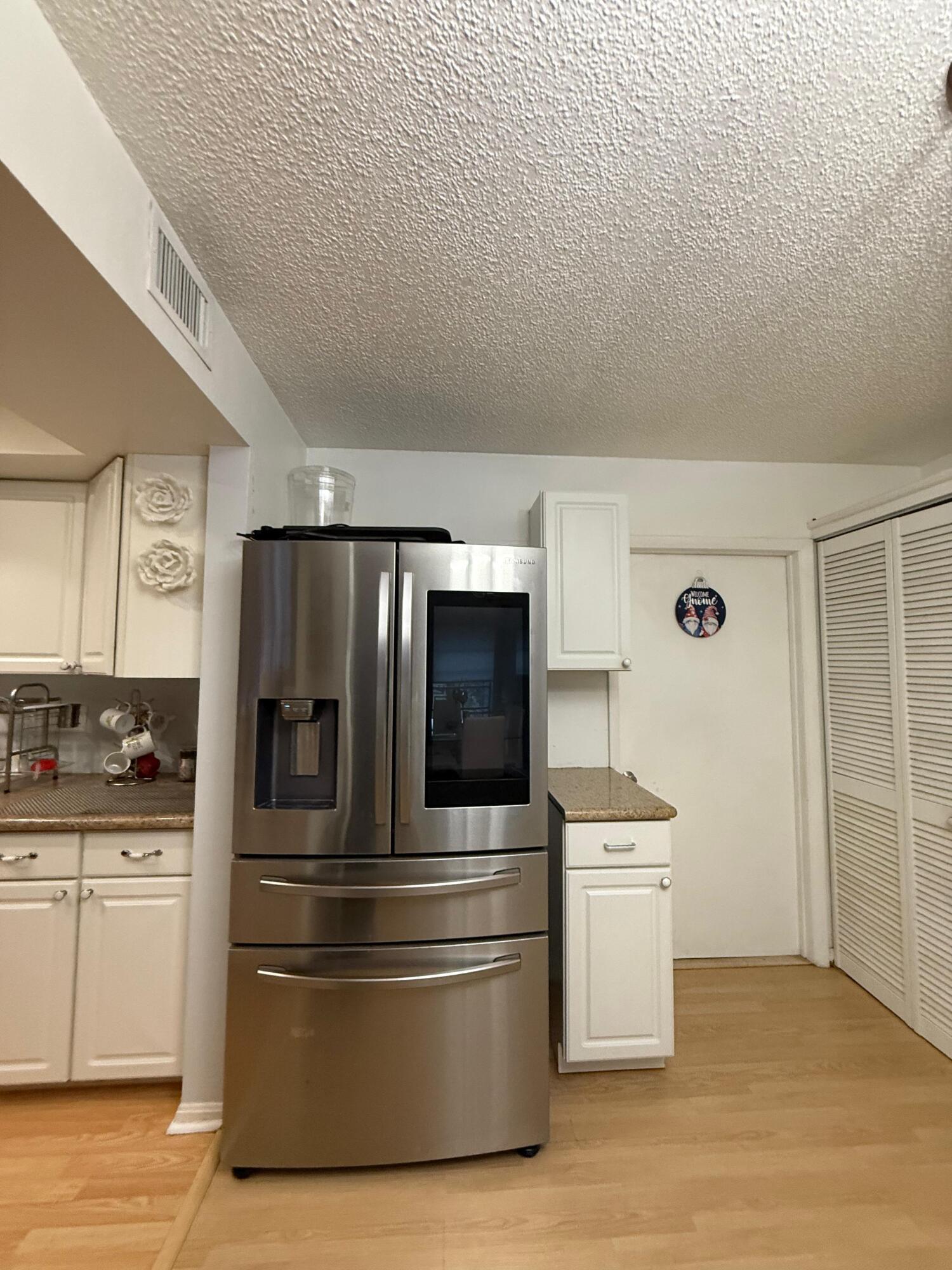 7024 Northwest 63rd Street Tamarac, FL 33321 - Photo 19 of 50 a kitchen with stainless steel appliances and white cabinets