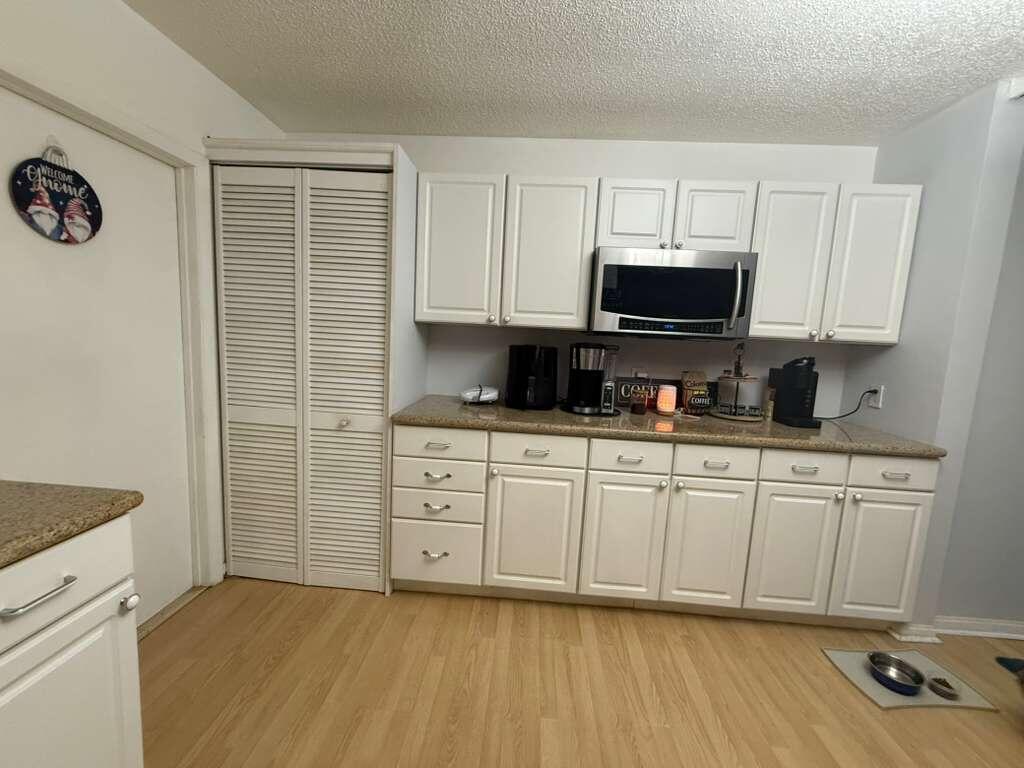 7024 Northwest 63rd Street Tamarac, FL 33321 - Photo 20 of 50 a kitchen with stainless steel appliances granite countertop a stove a sink and a microwave