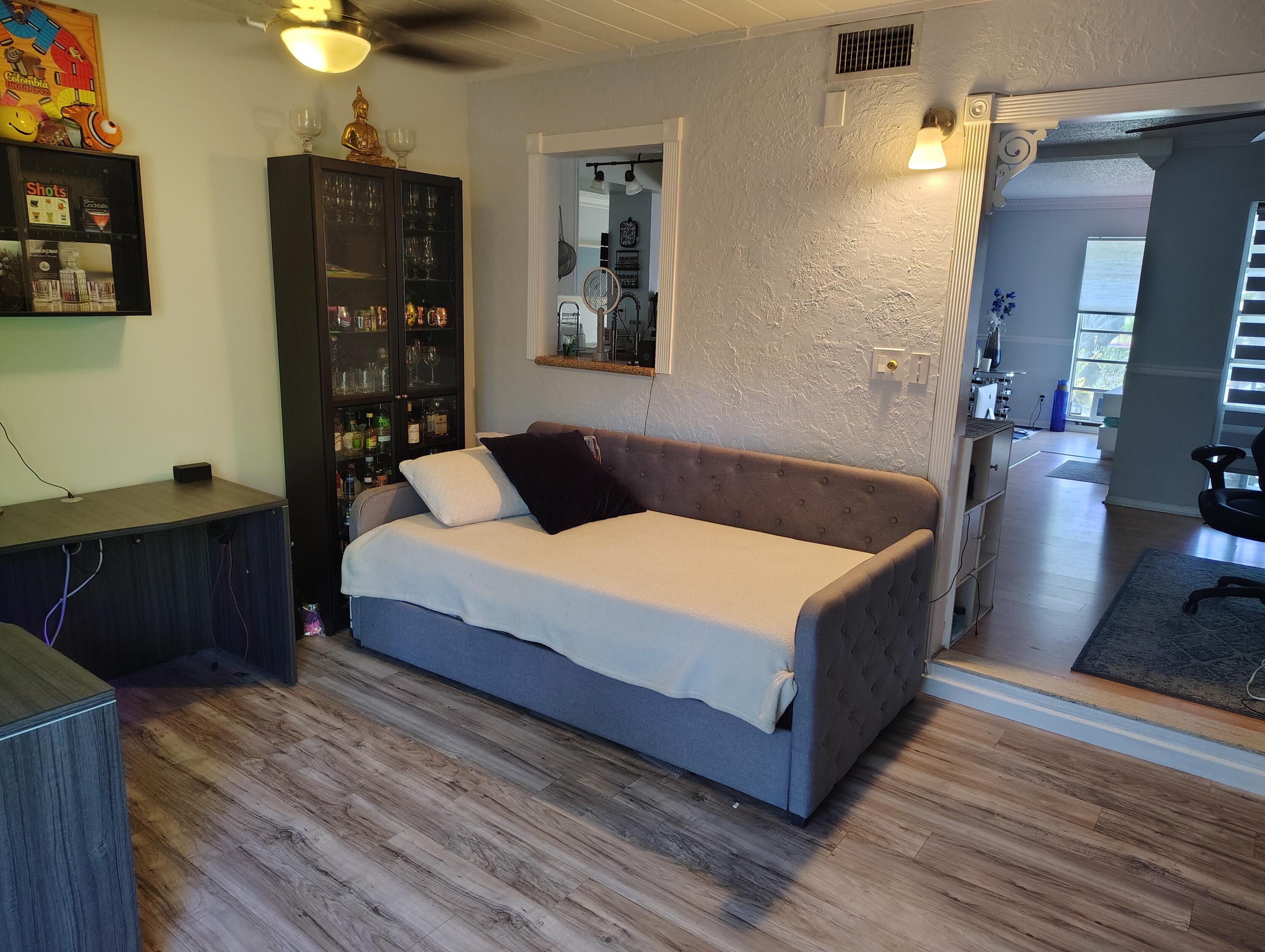 7024 Northwest 63rd Street Tamarac, FL 33321 - Photo 25 of 50 a living room with a bed furniture and a potted plant